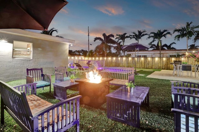 yard at dusk featuring a patio and a fire pit