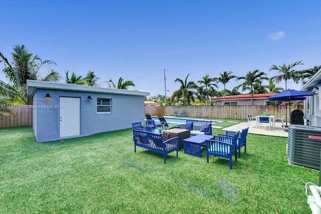 view of yard featuring a patio, an outbuilding, cooling unit, and a fenced in pool