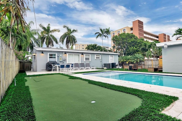 view of swimming pool with grilling area, central AC, and a patio area