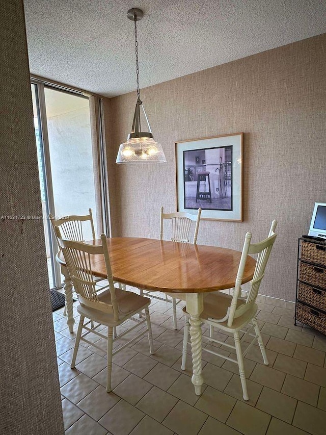 unfurnished dining area with light tile patterned flooring, a textured ceiling, and wallpapered walls