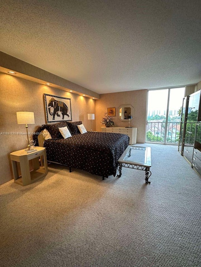 bedroom with a textured ceiling, carpet floors, and access to exterior