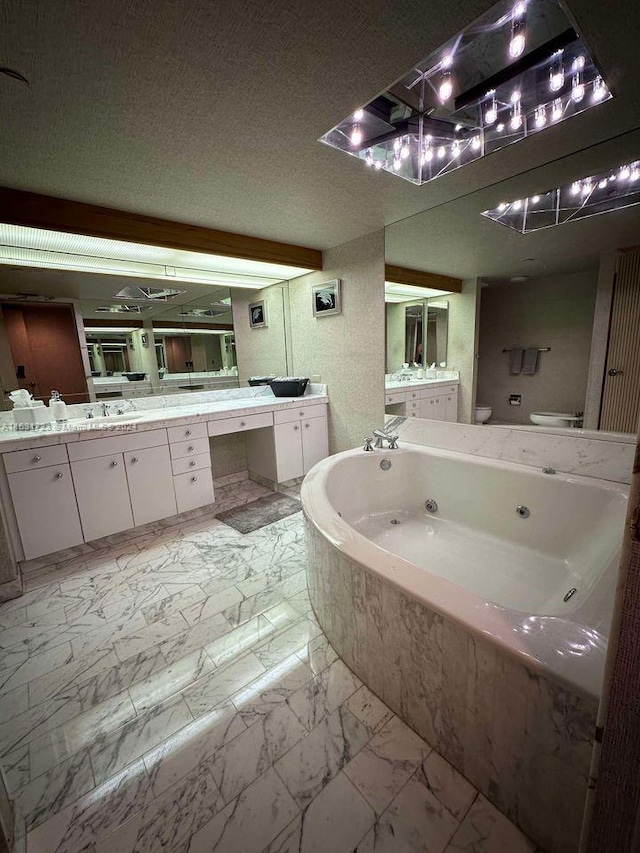 bathroom with toilet, a tub with jets, marble finish floor, a textured ceiling, and vanity