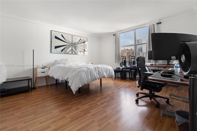 bedroom featuring hardwood / wood-style floors and crown molding