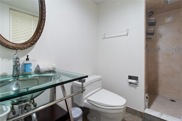 bathroom featuring a tile shower and toilet