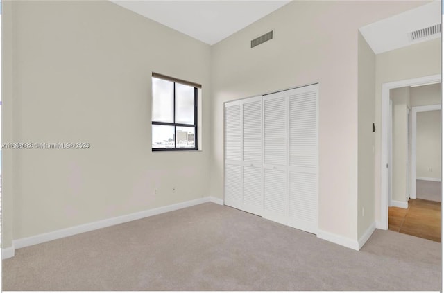 unfurnished bedroom with a closet and light carpet