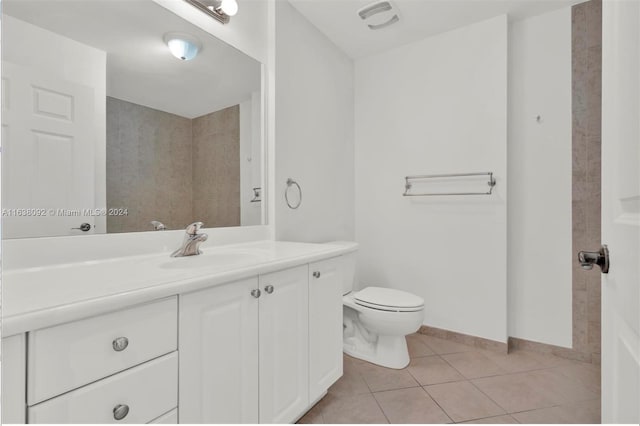 bathroom with toilet, vanity, and tile patterned floors