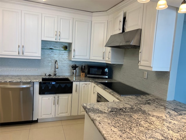 kitchen featuring appliances with stainless steel finishes, light stone countertops, light tile patterned floors, sink, and wall chimney range hood