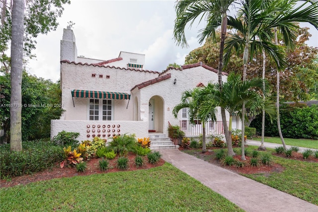 mediterranean / spanish house featuring a front lawn