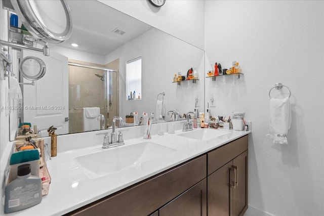 bathroom with walk in shower and dual bowl vanity