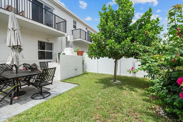 view of yard featuring a patio and a balcony