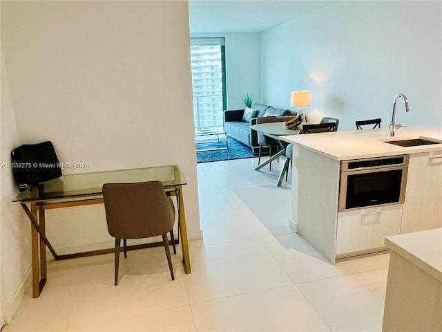 kitchen with light countertops, oven, and a sink
