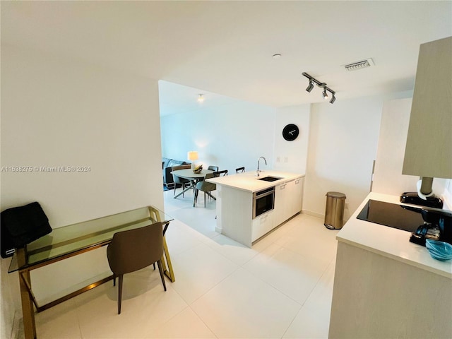 office with sink, track lighting, and light tile patterned floors