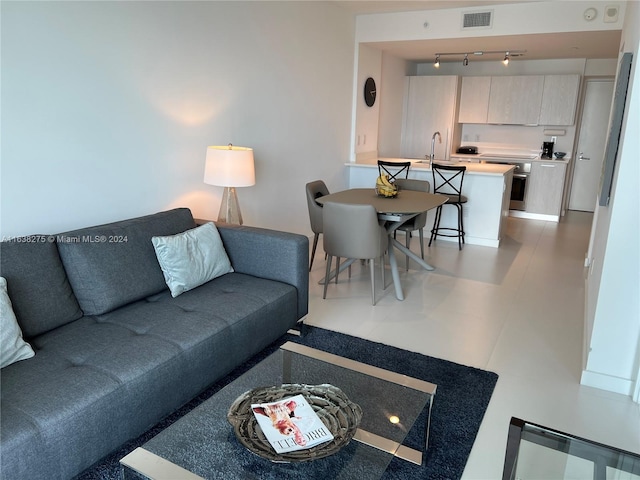 tiled living room with rail lighting and sink