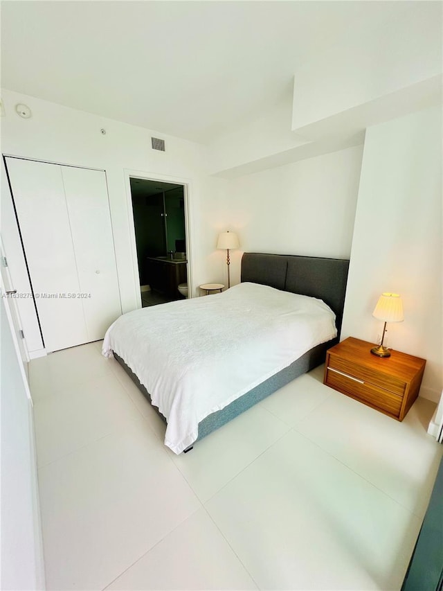 tiled bedroom with visible vents and a closet