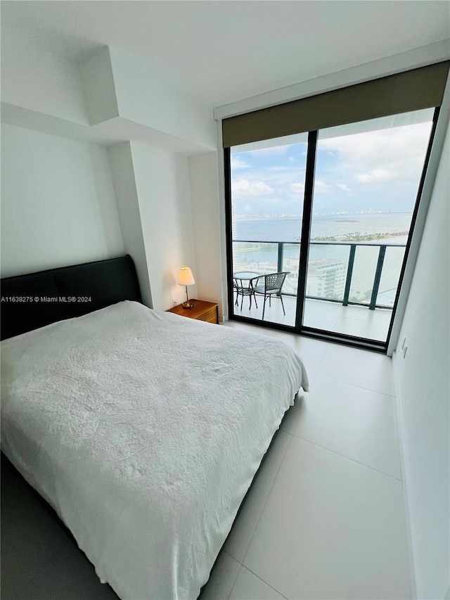 tiled bedroom featuring a water view and access to exterior