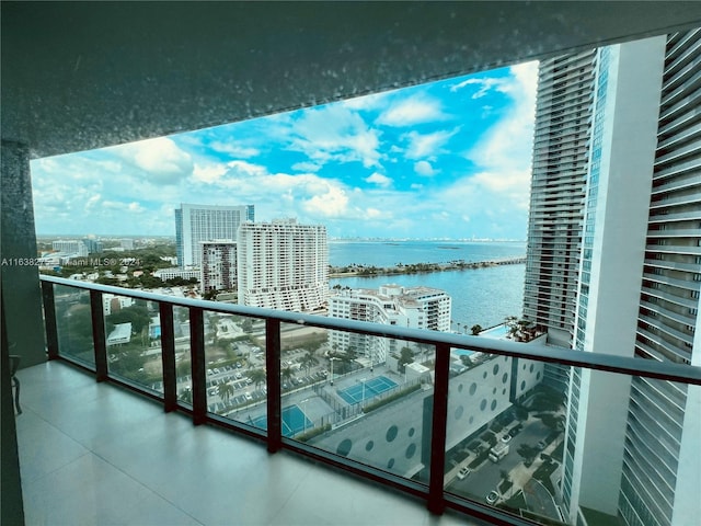balcony with a water view and a view of city