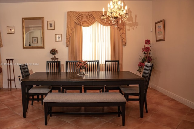 dining space featuring tile patterned floors and an inviting chandelier