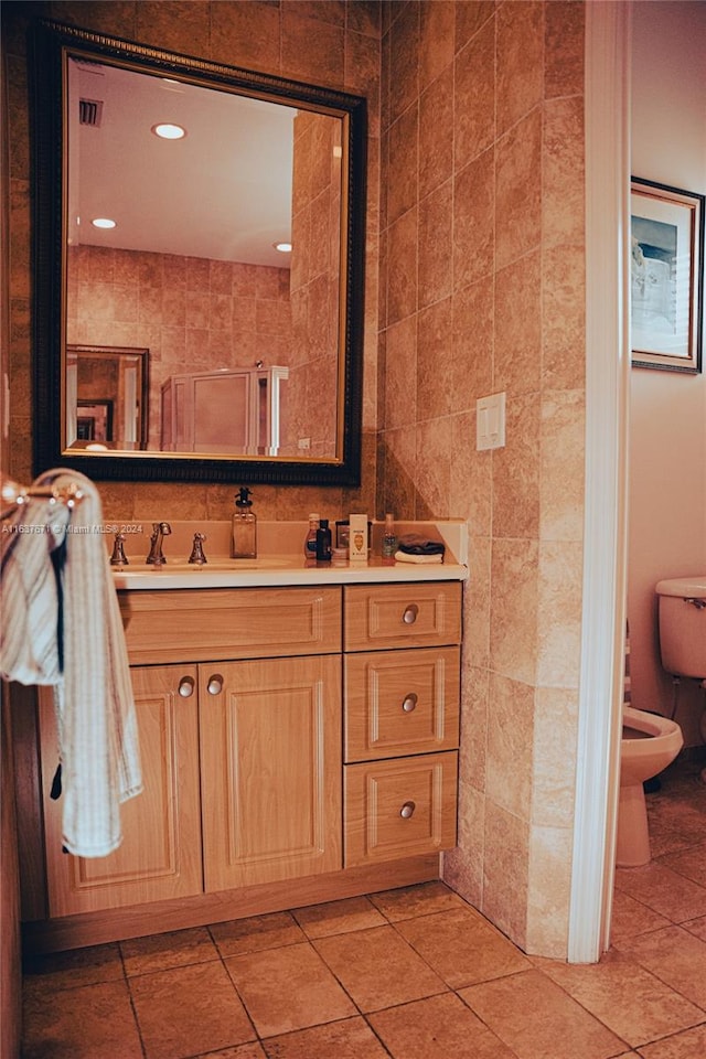 bathroom featuring tile walls, tile patterned floors, toilet, and vanity