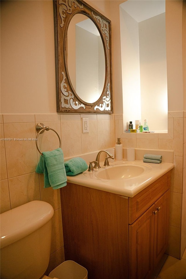 bathroom with vanity, toilet, tasteful backsplash, and tile walls