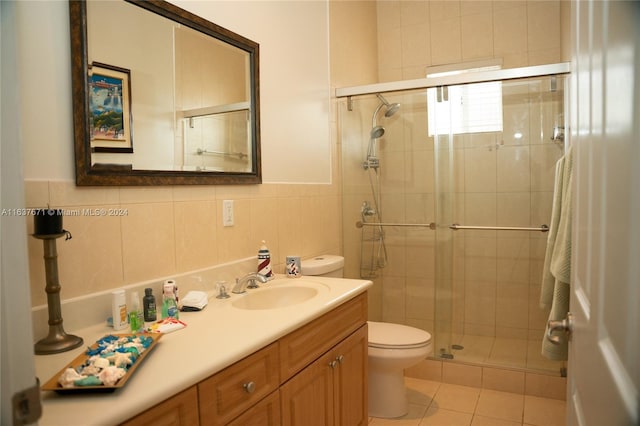 bathroom featuring a shower with shower door, tile walls, backsplash, tile patterned floors, and vanity