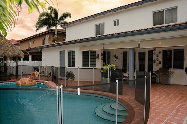 pool at dusk featuring a patio area