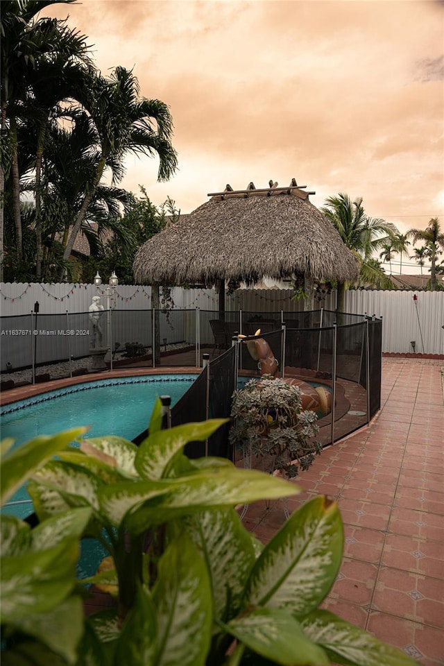 pool at dusk featuring a patio