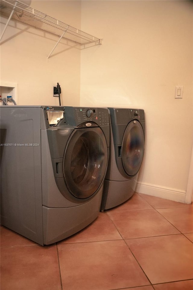 laundry area with light tile patterned flooring and washing machine and dryer