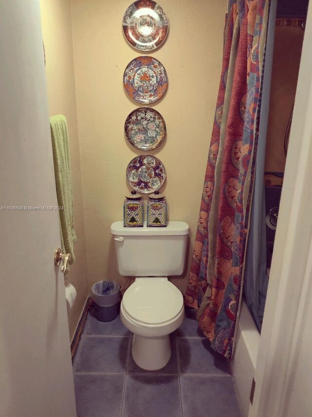 bathroom featuring tile patterned floors, toilet, and shower / bath combination with curtain