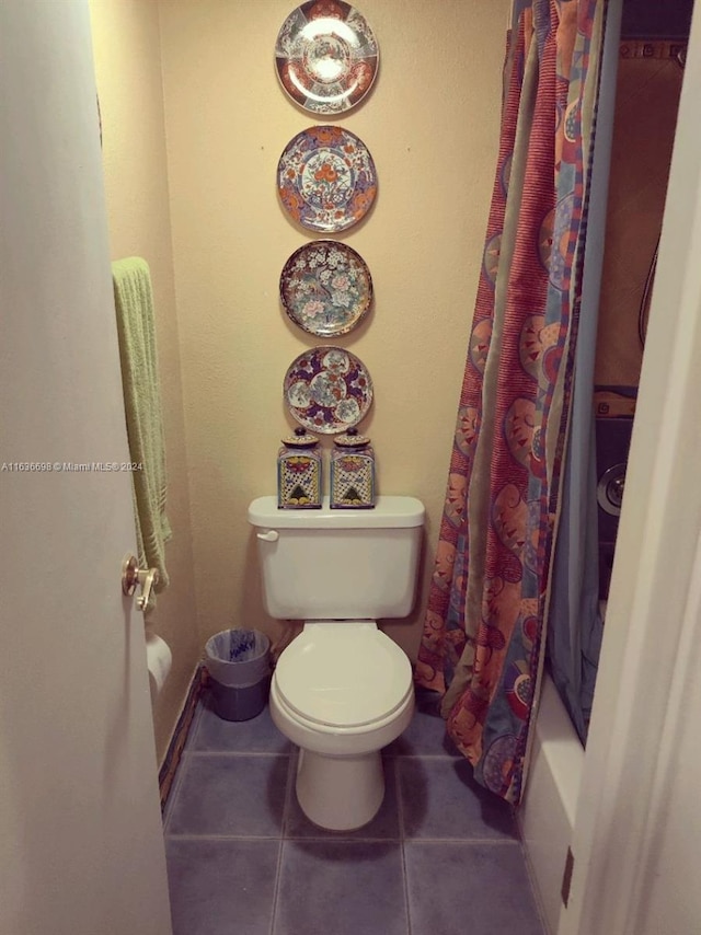 bathroom featuring toilet, tile patterned flooring, and shower / bath combo