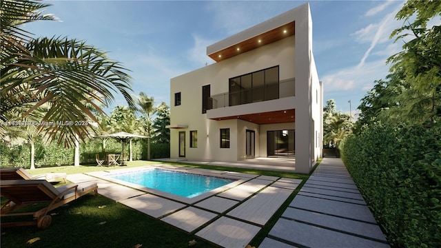 back of property with a balcony, a patio area, an outdoor pool, and stucco siding