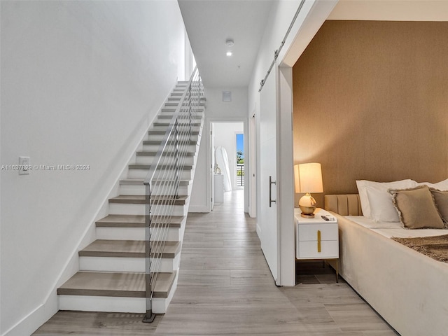 stairs featuring a barn door and hardwood / wood-style floors