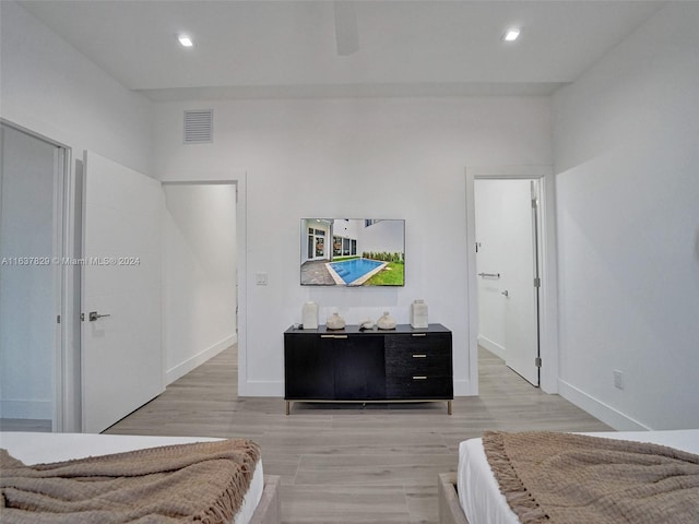 bedroom featuring ceiling fan, ensuite bathroom, and light wood-type flooring