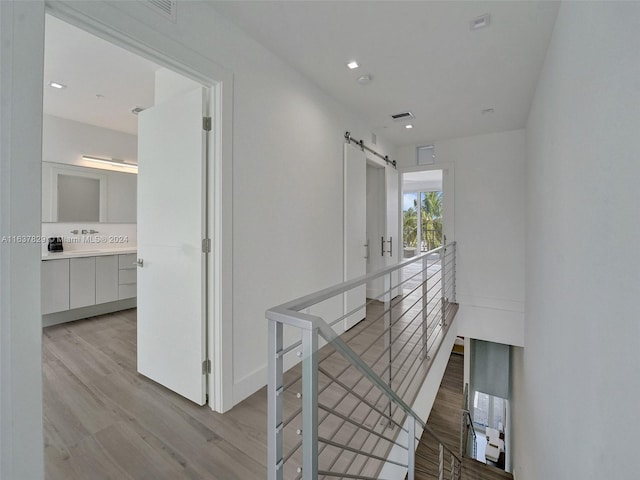 hall featuring light hardwood / wood-style floors and a barn door