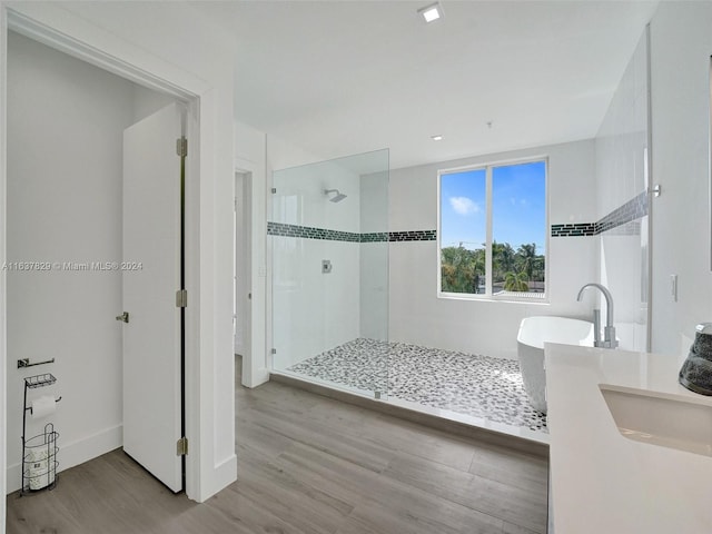 bathroom featuring independent shower and bath, sink, and hardwood / wood-style floors