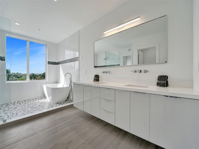 bathroom featuring vanity, separate shower and tub, and hardwood / wood-style floors