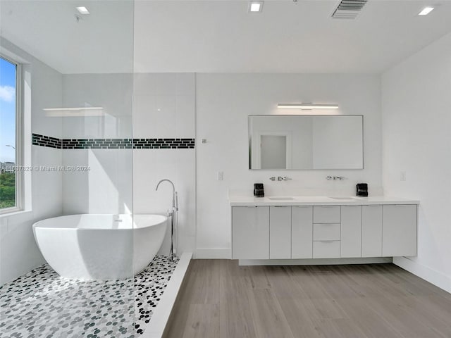 bathroom featuring hardwood / wood-style flooring, a bathing tub, and vanity