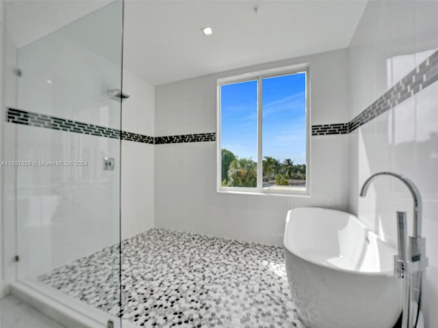 bathroom featuring separate shower and tub