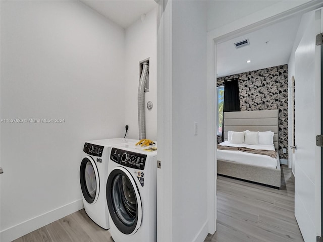 clothes washing area featuring washer and dryer and light wood-type flooring