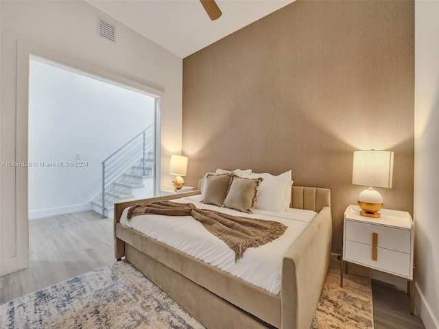 bedroom featuring ceiling fan, lofted ceiling, and light hardwood / wood-style floors