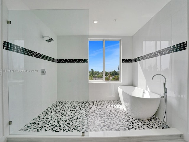 bathroom with shower with separate bathtub and tile patterned flooring