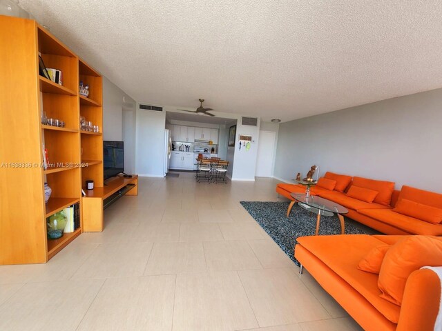 tiled living room featuring a textured ceiling and ceiling fan