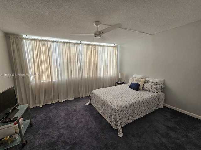 bedroom with a textured ceiling, ceiling fan, and dark carpet