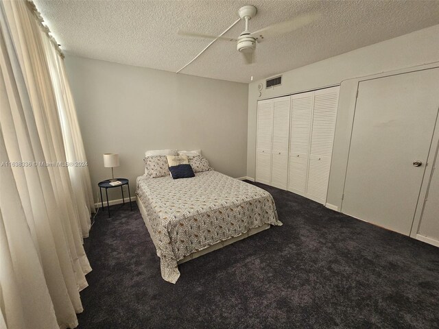 carpeted bedroom with a textured ceiling and ceiling fan