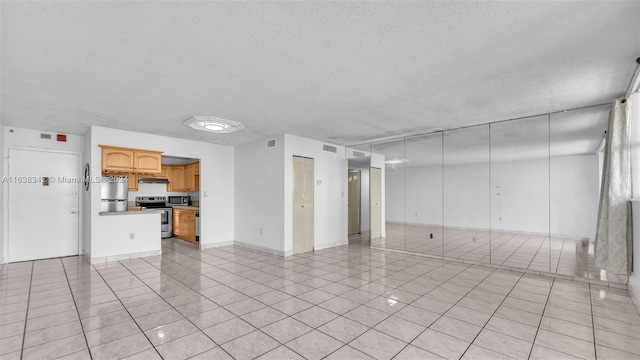 unfurnished living room with light tile patterned floors and a textured ceiling