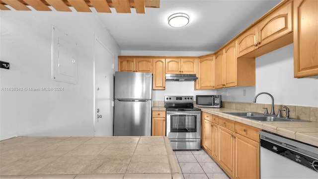 kitchen featuring appliances with stainless steel finishes, tile countertops, light tile patterned floors, and sink