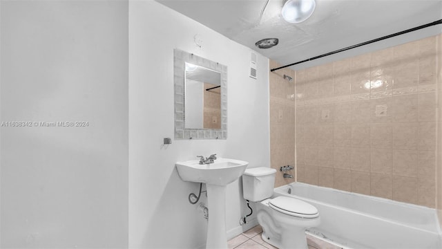 full bathroom with toilet, tiled shower / bath combo, tile patterned floors, and sink