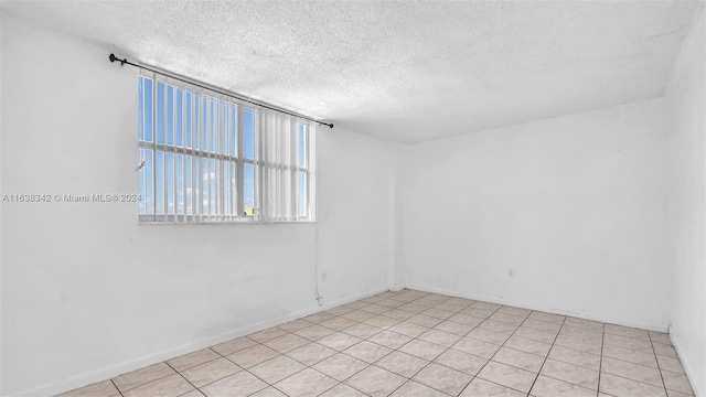 empty room featuring light tile patterned floors and a textured ceiling