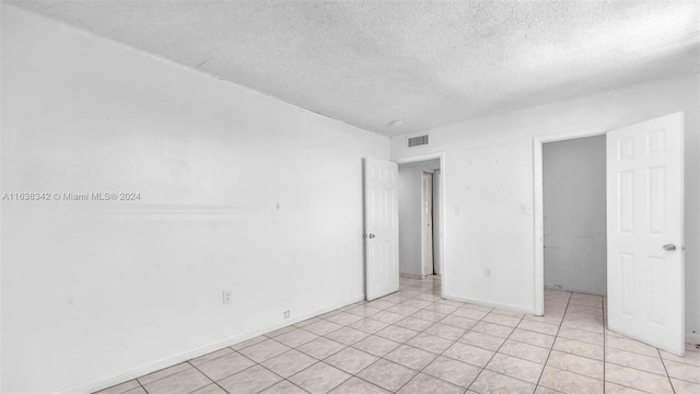 unfurnished bedroom featuring light tile patterned floors and a textured ceiling