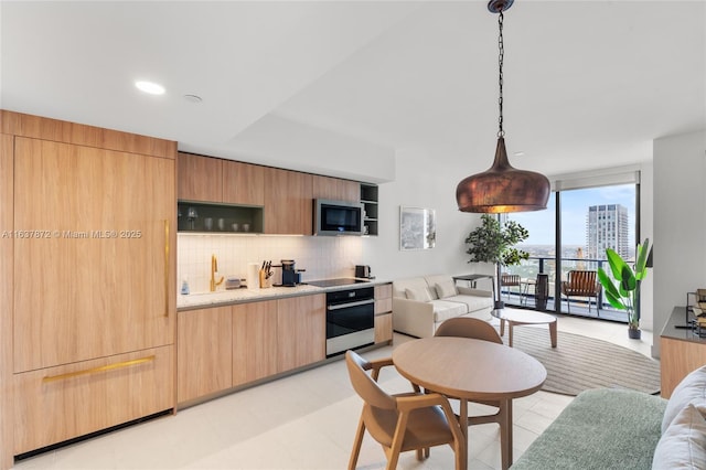 kitchen with pendant lighting, decorative backsplash, and stainless steel appliances