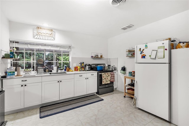 kitchen featuring white cabinetry, white fridge, electric stove, and light tile patterned floors